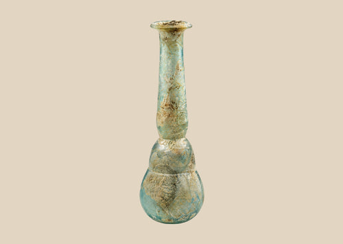 Ancient Roman pale turquoise blown glass balsamarium, 2nd–3rd Century CE. Double-gourd body with tapering neck and outfolded lip, featuring natural iridescent patina. Hand-blown vessel used for perfumes, ointments, and luxury grooming, reflecting Roman craftsmanship, refinement, and elite culture.