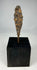 Ancient iron arrowhead relic mounted on black display base, front view.