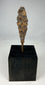 Ancient iron arrowhead relic mounted on black display base, front view.