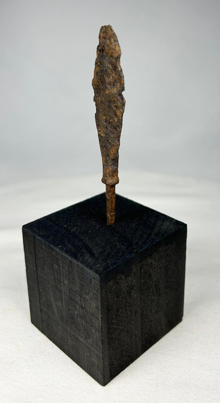 Side profile of ancient European iron weapon point displayed vertically