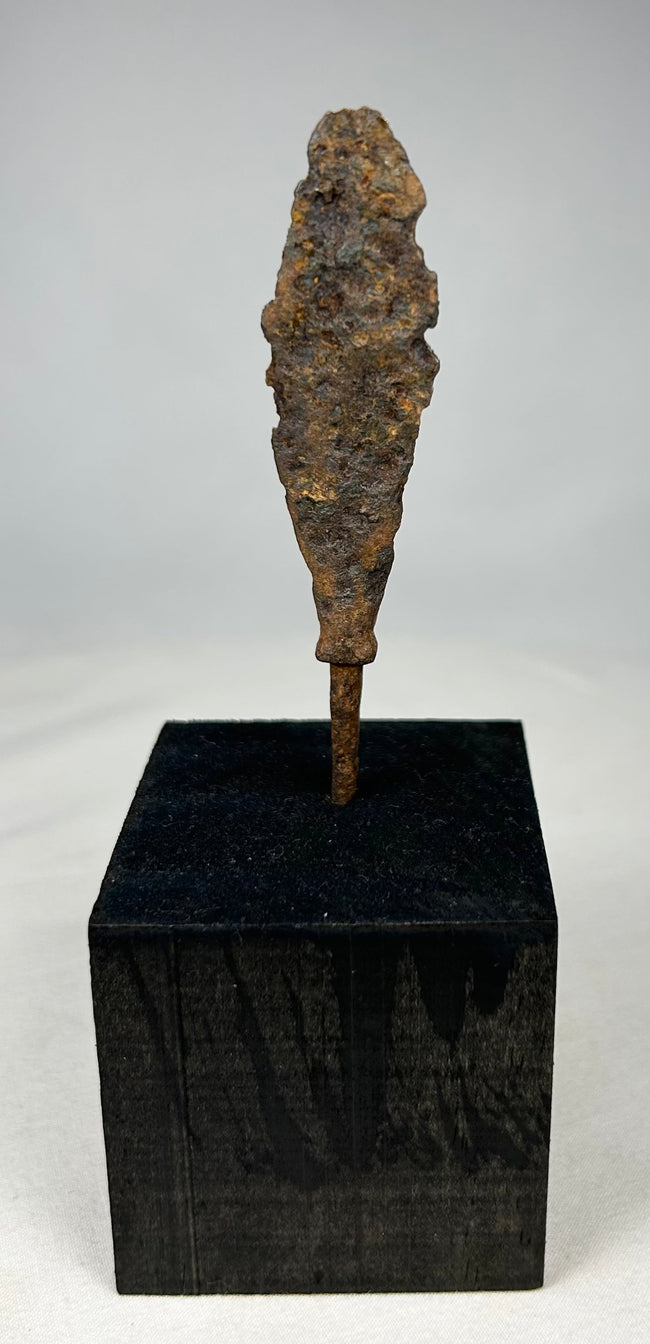 Close-up of corroded iron arrow or javelin tip with textured archaeological patina