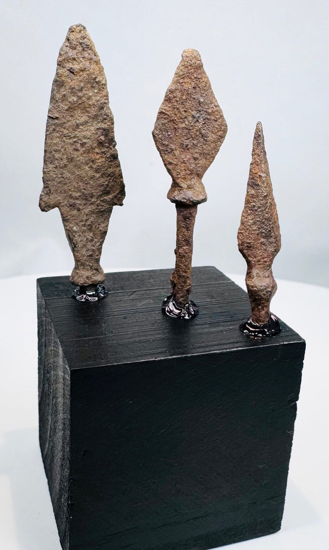 Elongated archaeological iron arrowhead with pronounced shoulders and surviving tang