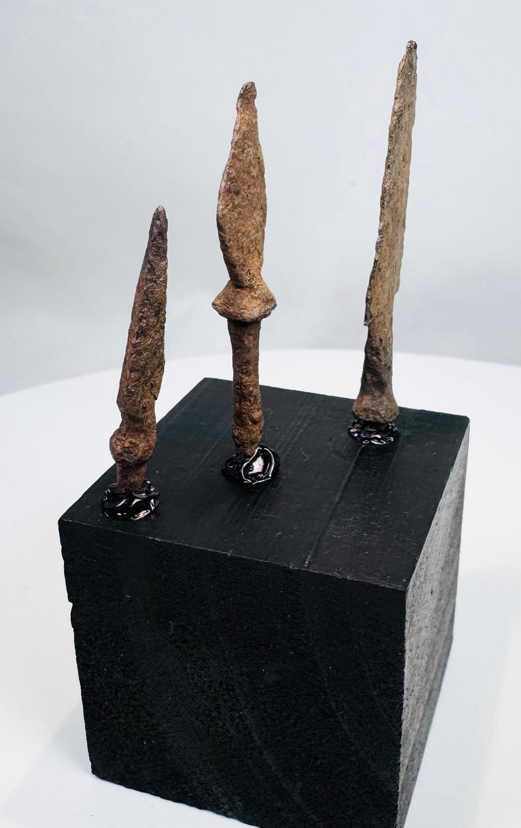 Small triangular hand-forged iron arrowhead with heavy mineral encrustation