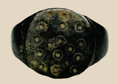 Ancient Roman bronze ring, size 7 US, featuring a flat bezel engraved with irregular “ring and dot” motifs symbolizing the sun, with authentic patina and well-preserved surface from the 1st–3rd century CE.