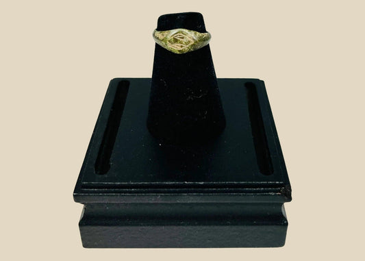 Authentic Roman bronze signet ring, circa 100–300 CE, with oval bezel engraved with geometric intaglio diamond motif, slender tapered band, and rich green patina from centuries of burial, used for sealing documents and personal identity.