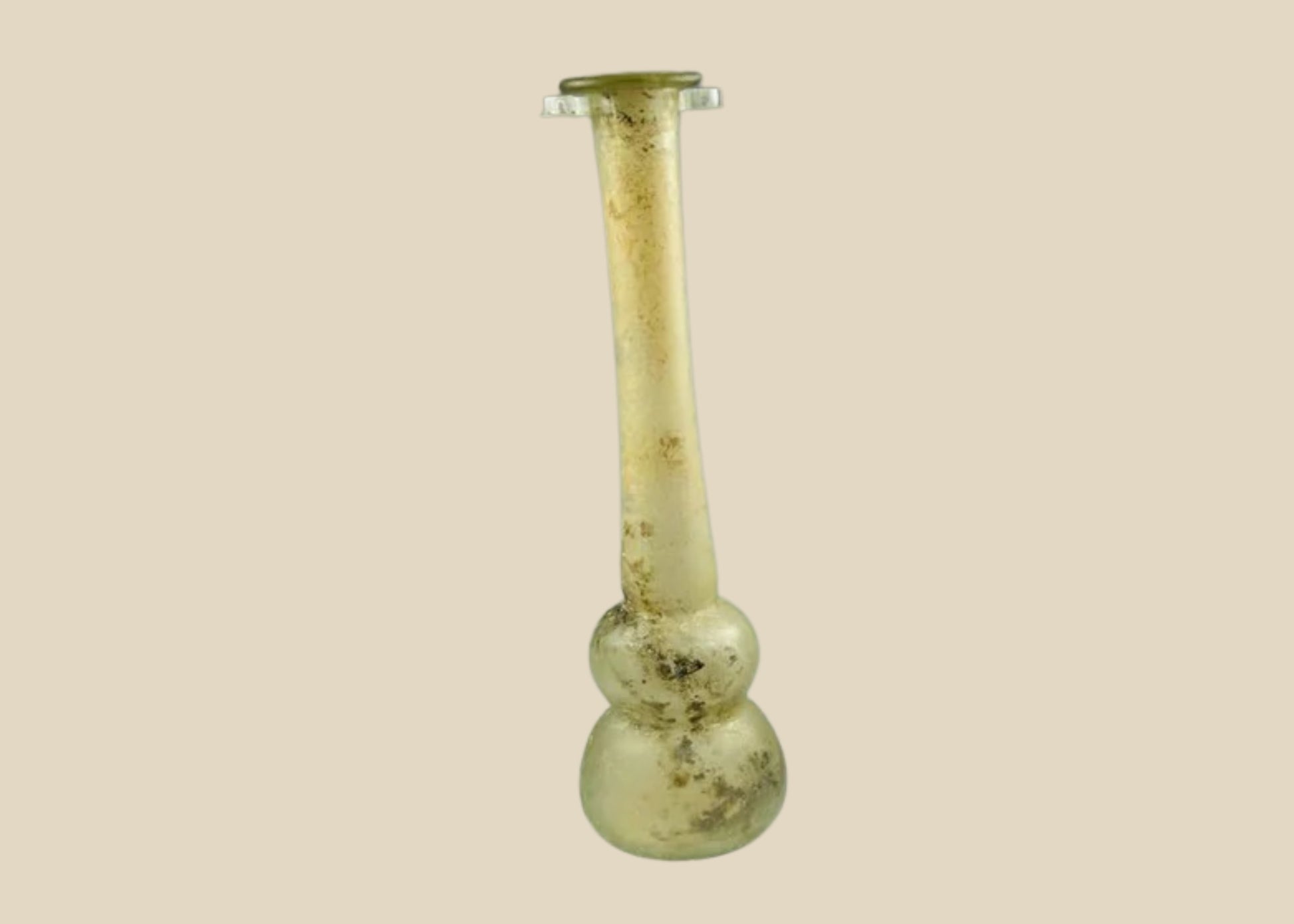 Ancient Roman clear glass double gourd balsamarium from the Eastern Mediterranean, 2nd–3rd Century CE. Features two globular sections joined by a slender neck, naturally iridescent patina, and substantial size for holding perfumes or balms. Reflects Roman glassmaking sophistication, luxury, and daily bathhouse culture.