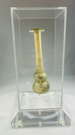 Ancient Roman clear glass double gourd balsamarium from the Eastern Mediterranean, 2nd–3rd Century CE. Features two globular sections joined by a slender neck, naturally iridescent patina, and substantial size for holding perfumes or balms. Reflects Roman glassmaking sophistication, luxury, and daily bathhouse culture.