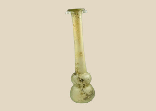 Ancient Roman clear glass double gourd balsamarium from the Eastern Mediterranean, 2nd–3rd Century CE. Features two globular sections joined by a slender neck, naturally iridescent patina, and substantial size for holding perfumes or balms. Reflects Roman glassmaking sophistication, luxury, and daily bathhouse culture.
