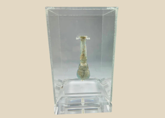 Ancient Roman pale turquoise blown glass balsamarium, 2nd–3rd Century CE. Double-gourd body with tapering neck and outfolded lip, featuring natural iridescent patina. Hand-blown vessel used for perfumes, ointments, and luxury grooming, reflecting Roman craftsmanship, refinement, and elite culture.