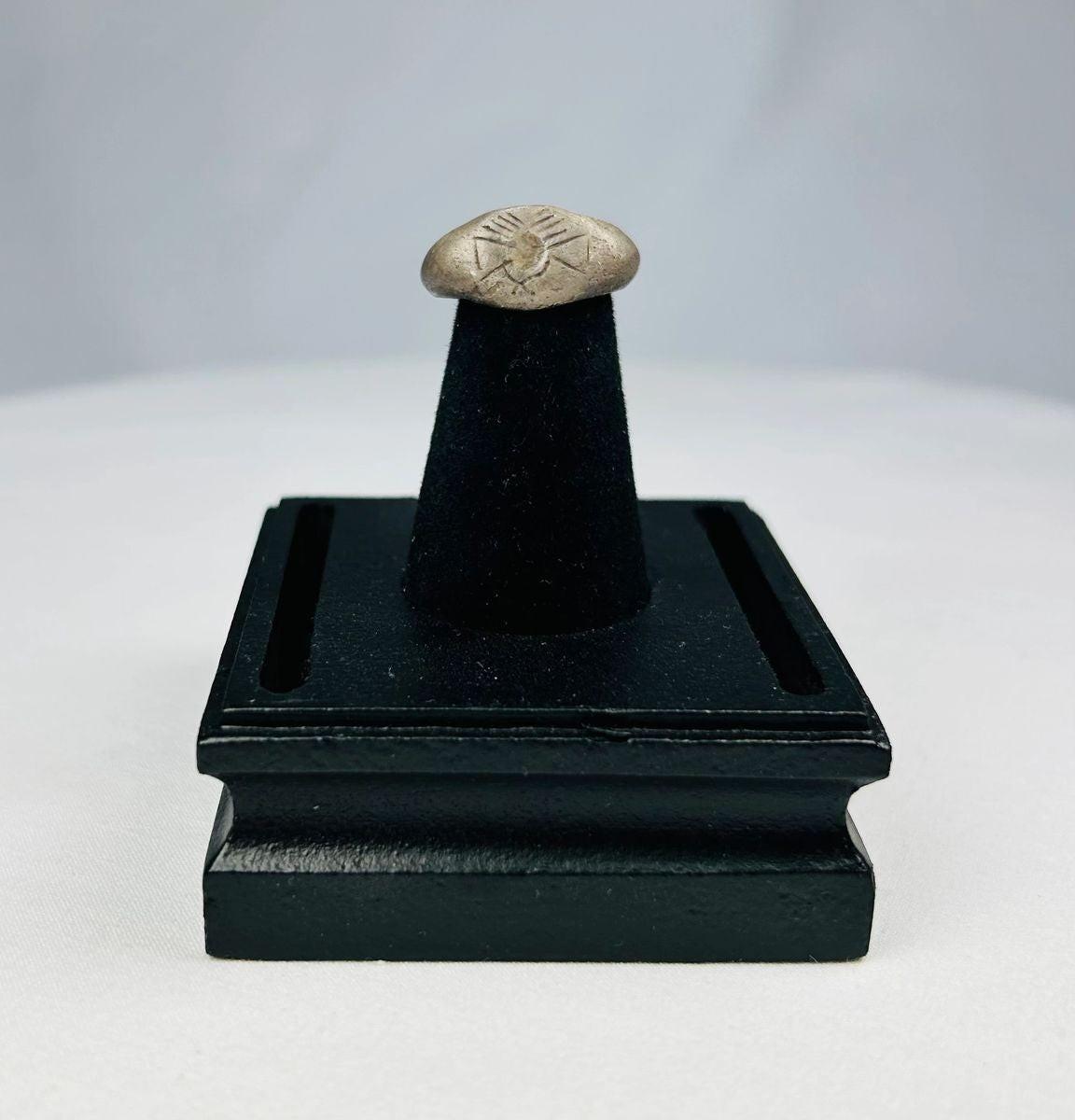 Ancient silver signet ring with finely engraved sunburst motif on bezel, thin rounded band, and natural aged patina, dating to the Late Roman to Early Byzantine period, circa 200–500 CE.