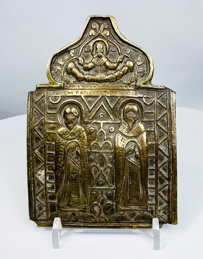 Nineteenth-century Russian Orthodox bronze folding icon center panel depicting two haloed saints and Christ above.