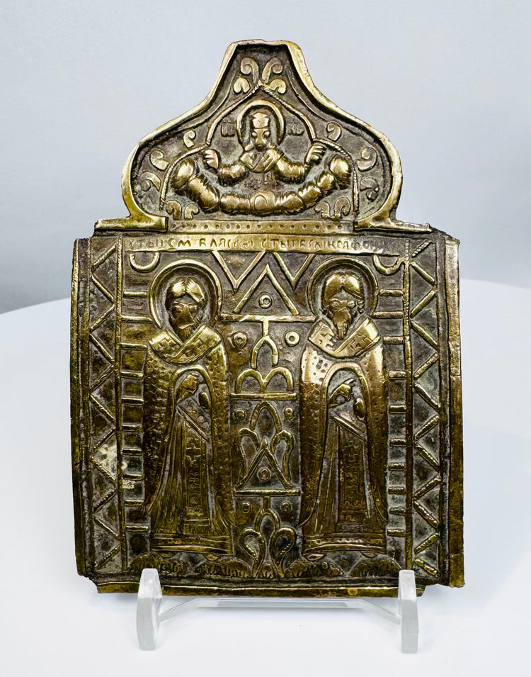 Nineteenth-century Russian Orthodox bronze folding icon center panel depicting two haloed saints and Christ above.