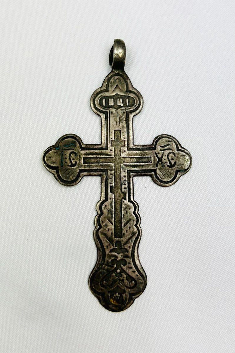 Antique Russian Orthodox silver cross pendant, 18th Century CE. Classic cruciform shape with additional upper crossbar and engraved Cyrillic inscriptions, including “IC XC” for Jesus Christ. Compact wearable devotional pendant with natural silver patina, reflecting Eastern Orthodox artistry, faith, and spiritual symbolism.
