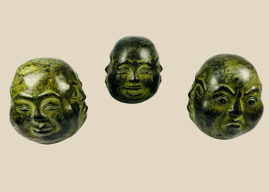 20th century Himalayan cast metal Buddha heads, sand-filled, patinated bronze finish, set of three in traditional brocade box, devotional and ritual meditation objects