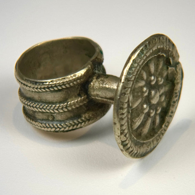 Late 19th-century antique ring with floral relief centerpiece and softly aged silver surface