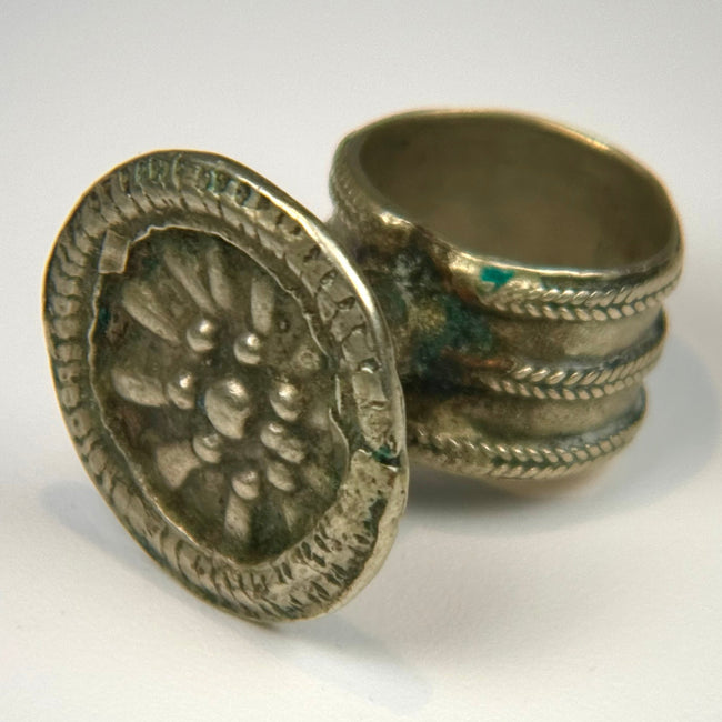 Victorian-era silver-toned finger ring with embossed rosette motif and tapered intact band