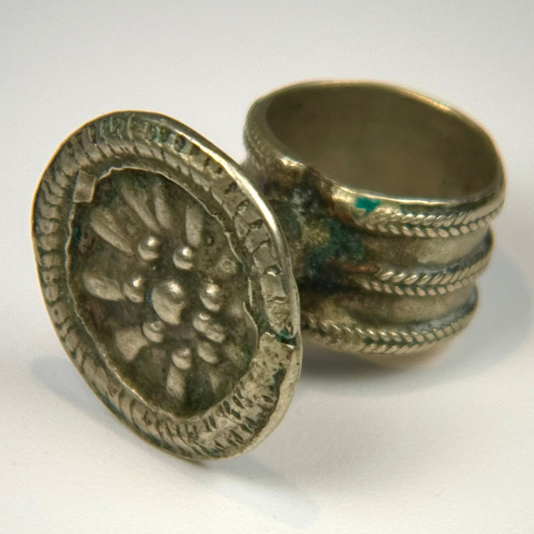 Victorian-era silver-toned finger ring with embossed rosette motif and tapered intact band