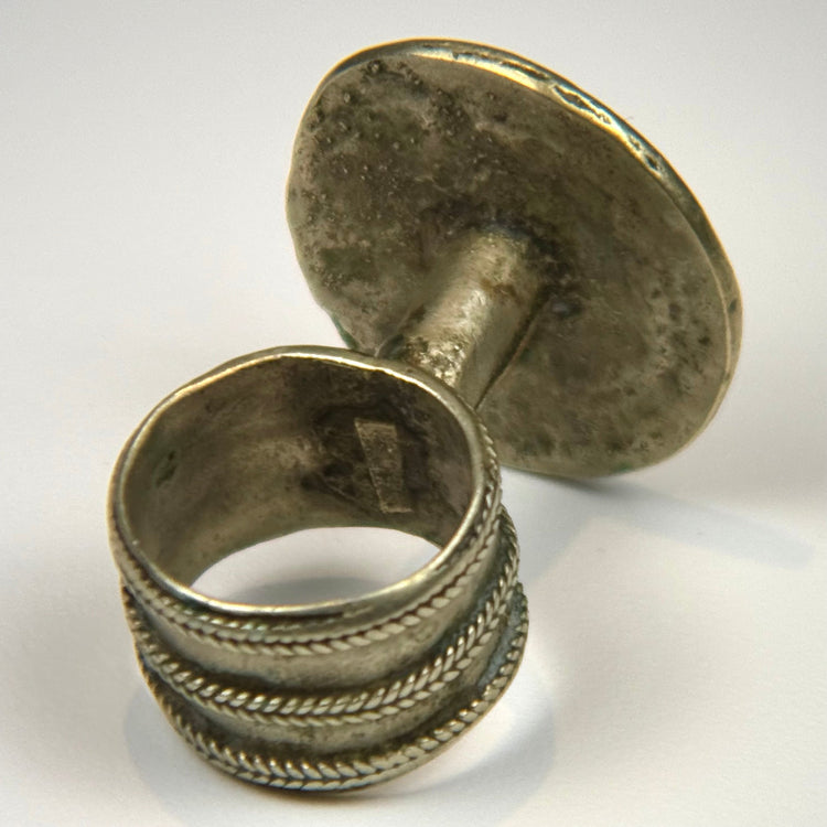 Silver-toned antique ring with decorative flower motif, beaded frame, and age-consistent surface wear