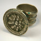 Antique silver-colored ring featuring a raised floral rosette design within a round decorative bezel