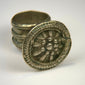 Antique silver-toned ring with circular floral bezel, detailed relief work, and natural surface patina