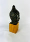 Antique Buddhist sculpture with closed eyes gentle smile and intricate hair curls
