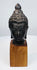 Cast bronze Buddha head with finely detailed hair, tranquil expression, and wooden display base