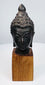 Cast bronze Buddha head with finely detailed hair, tranquil expression, and wooden display base