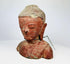 Close-up of antique wooden Buddha face showing serene expression and finely carved features.