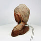 Side profile of Southeast Asian Buddha bust highlighting elongated earlobes and ushnisha.