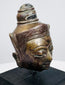 Small Southeast Asian metal Buddha head with detailed relief decoration and black wooden base