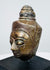 Antique Buddha head with half-closed eyes, slender nose, and detailed crown ornamentation