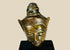 Bronze Buddha head on black display base, featuring serene facial expression, pointed ushnisha, and natural greenish patina, likely from Thailand or Cambodia, 18th–19th century CE.