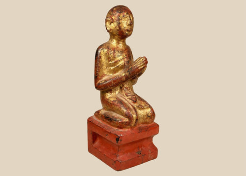 Hand-carved Burmese wooden monk statue, 18th–19th century, with gold leaf and red lacquer, kneeling in prayerful devotion.