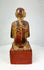 Close-up of the statue’s pedestal base with traces of red lacquer and traditional Burmese craftsmanship.