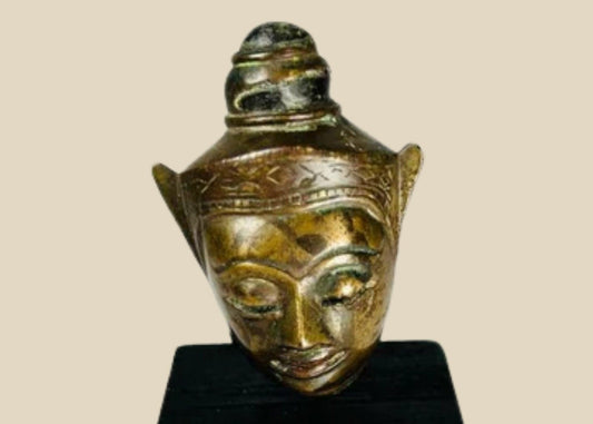 Bronze Buddha head on black display base, featuring serene facial expression, pointed ushnisha, and natural greenish patina, likely from Thailand or Cambodia, 18th–19th century CE.