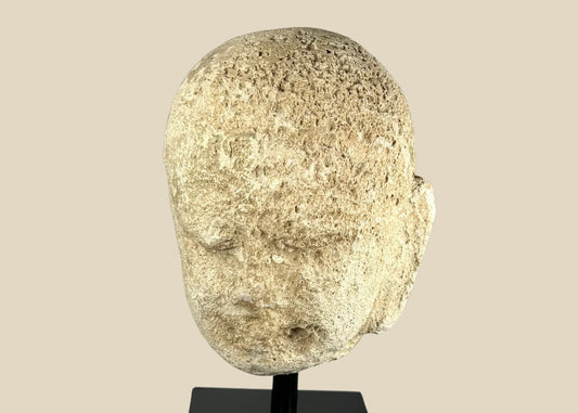 Southeast Asian carved stone Buddha head with serene expression and closed eyes, 13th–14th century, mounted on a modern black stand, Burma or Thailand.