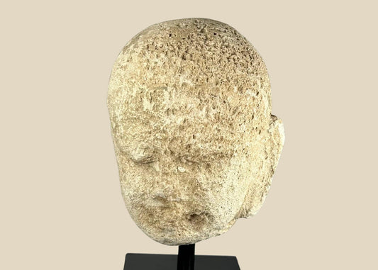 Southeast Asian carved stone Buddha head with serene expression and closed eyes, 13th–14th century, mounted on a modern black stand, Burma or Thailand.