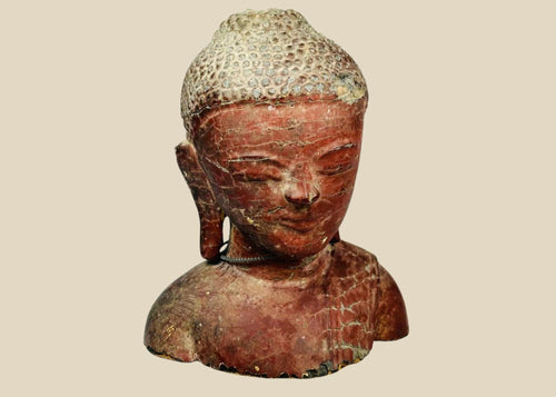 19th-century Southeast Asian wooden Buddha bust, likely Thailand or Burma, with serene features, red lacquer, gold gilt remnants, and metal chain detail.