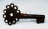 Spanish colonial-era key in oxidized iron, measuring 2.75 inches, with preserved head, shank, and bit.