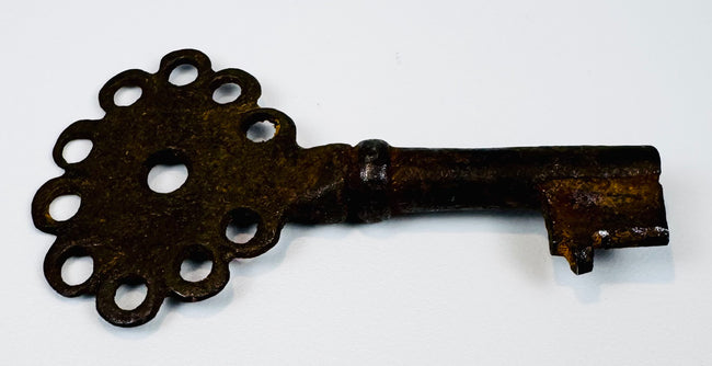 Antique Spanish Empire key forged from iron, featuring a compact form, pierced bow, and aged patina.