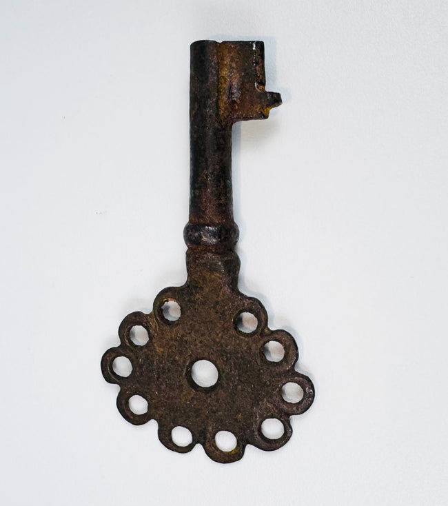 Spanish colonial iron key from the 16th–18th century with pierced head and naturally oxidized surface.