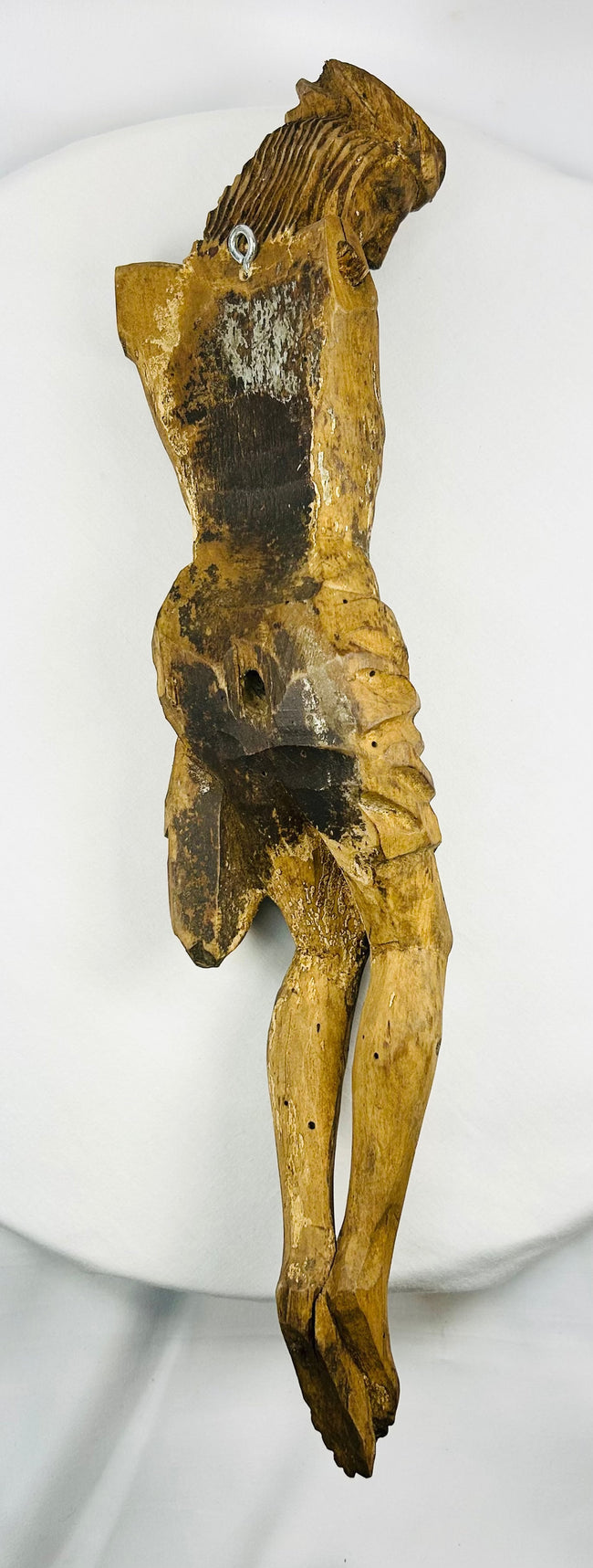 Hand-carved Spanish Colonial wooden Christ figure with downward gaze and centuries of devotional wear