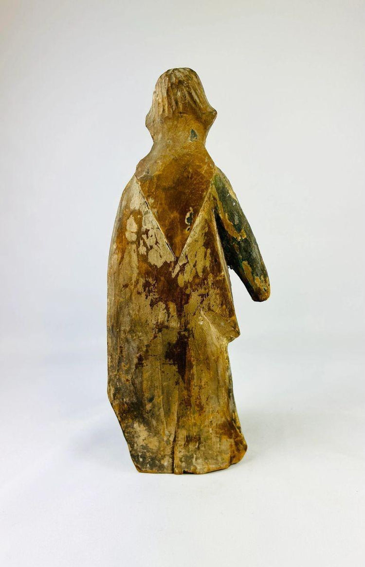 Antique European or Spanish Colonial wooden saint figure with flowing robes, weathered surface, and authentic age wear