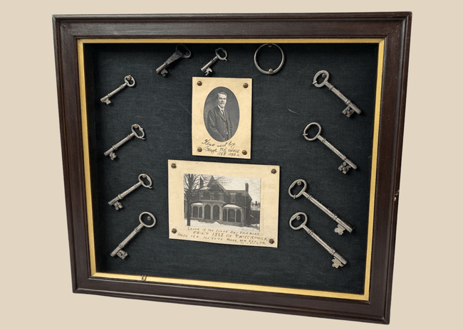 Framed 19th-century display with eleven iron keys, portrait of night watchman Hugh Newell, and early photograph of T. McCormick’s 1867 factory, preserved in a wooden shadowbox.