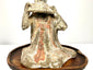 Chinese Tang Dynasty terracotta funerary figure featuring a finely modeled pan flute and intricate draped robe details.