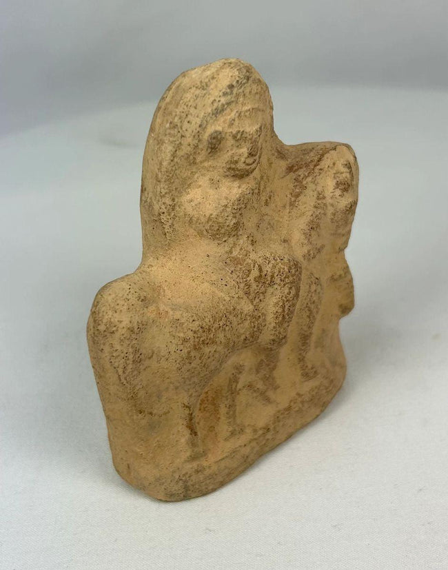 Ancient terracotta horse and mounted rider sculpture with worn surface and patina.