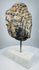 Historic carved stone Buddha head mounted on a modern marble display base