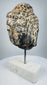 Historic carved stone Buddha head mounted on a modern marble display base