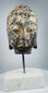 Antique Southeast Asian religious sculpture featuring a hand-carved stone Buddha head