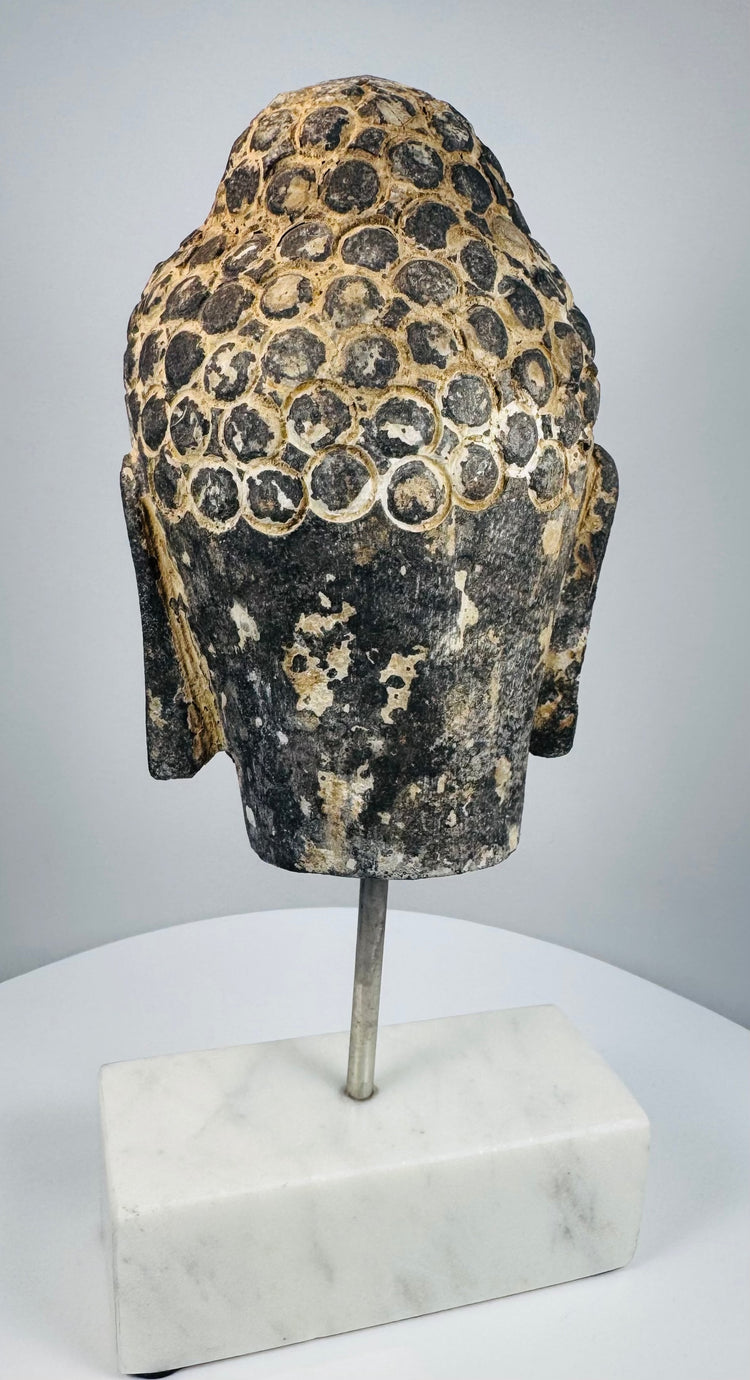 Antique Buddhist sculpture from Southeast Asia with remnants of dark and ochre pigment